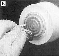 After friction fitting the lid into a waste block, turn the lid cove lines with a spindle gouge.
